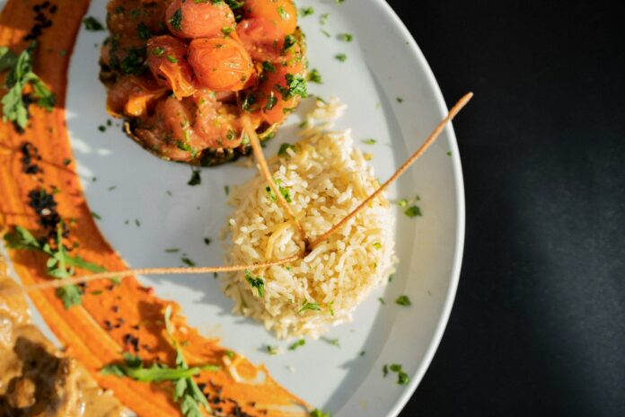 a white plate topped with meat and rice
