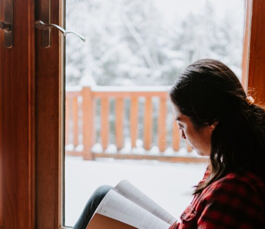 더 많은 독서를 위한 계획 세우기 woman in red and black striped long sleeve shirt and blue denim jeans sitting on brown